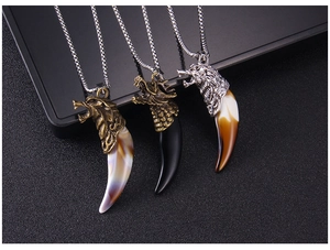 Detailed close-up of tribal wolf tooth pendants in bronze, black, and silver finishes