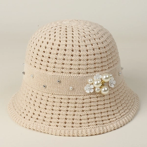 Detailed close-up of breathable beige knit sun hat with elegant pearl floral decoration