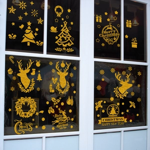Detail of gold glitter Christmas window stickers with reindeer and tree on white frame