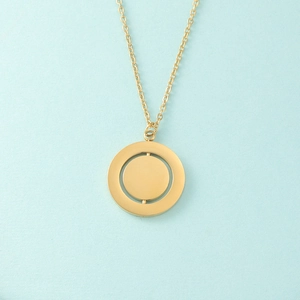 Detail of a rotating geometric gold disk pendant with a 360-degree spinning inner circle