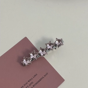 Detail of five-star silver hair clip set with pink crystals on a sweet decorative card