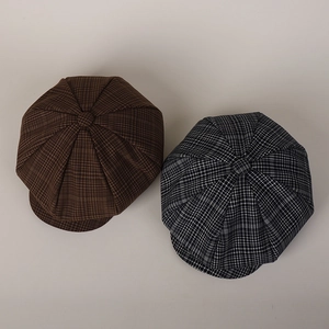 Detail of coffee and black-white plaid newsboy hats showing eight-panel stitching