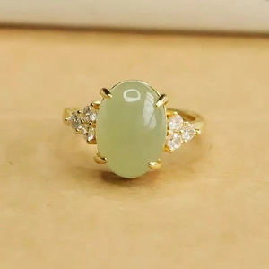 Nahaufnahme eines goldenen Vintage-Rings mit grünem Edelstein und Diamantbesatz