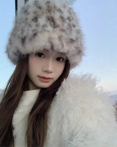 Close-up of leopard print faux fur bucket hat and white plush jacket texture