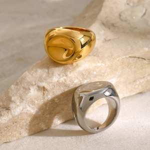 Detail of 18k gold and silver chunky spiral rings on natural beige stone texture