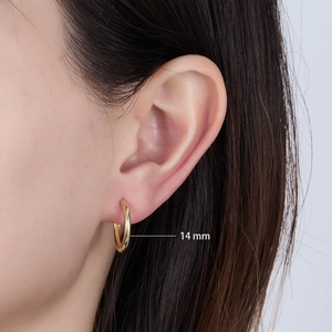 Detail of 14mm gold sterling silver hoop earring shown worn on model for scale