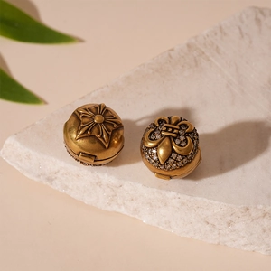 Detail of vintage gold earrings with zircon iris and star relief on white stone