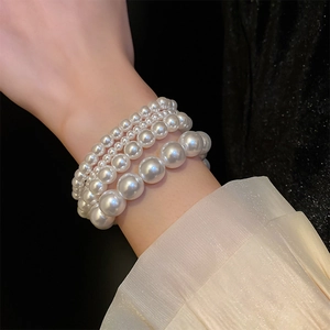 Detail of layered French vintage pearl stretch bracelet set with multi-sized white pearls