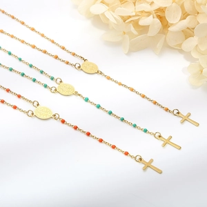 Detailed shot of three gold religious necklaces with colorful beads and cross pendants