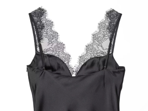 Detail van zwarte satijnen camisole top met fijne wimperkant en een diepe V-hals
