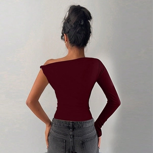 Detail of slim fit one-shoulder long sleeve top in dark red with knot design