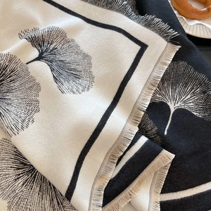 Macro view of black and white ginkgo leaf pattern and delicate fringe on the cashmere scarf