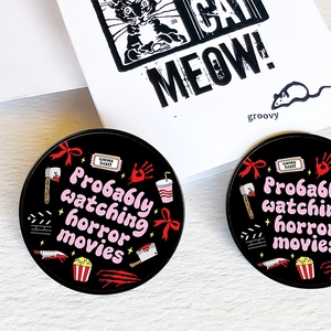 Detail of horror movie pins featuring blood splatters, popcorn, and cinema tickets