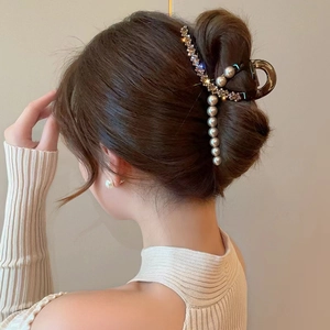 Elegant shark clip with pearls and rhinestones holding hair in a bun hairstyle