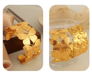 Detailed macro shot of 18K gold-plated wide cuff bangle with butterfly floral engraving