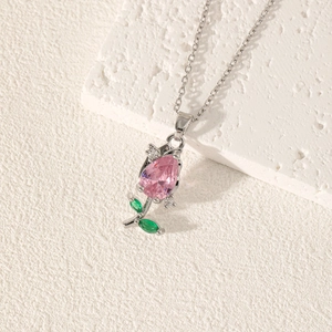 Close-up of tulip necklace with pink teardrop gemstone and green leaf accents