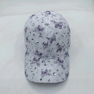 Close-up of white lace baseball cap with purple butterflies, rhinestones and star studs