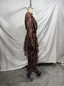 Dettaglio dell'abito in chiffon marrone paisley con orlo a balze e cintura nera in vita