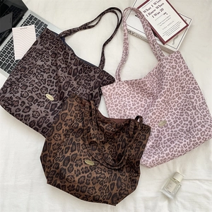 Leopard print canvas tote bags in brown, pink, and grey arranged with work essentials