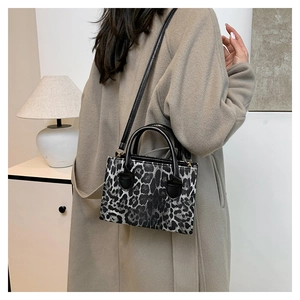 Lifestyle shot of large leopard print handbag with black handles and crossbody strap