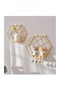 Detail of Nordic golden hexagonal wall shelf with wooden base and cat ornaments