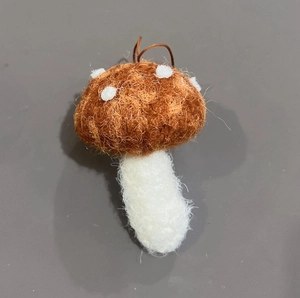 Dettaglio di fungo di peluche con cappello maculato marrone e trama in fibra rustica
