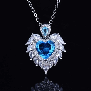 Macro shot of heart-shaped blue topaz pendant with sparkling crystal angel wings