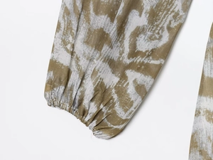 Detalle de puño elástico con volantes en vestido de gasa con estampado abstracto
