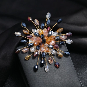 Macro detail of handmade copper wire snowflake brooch with blue crystal beads on black silk