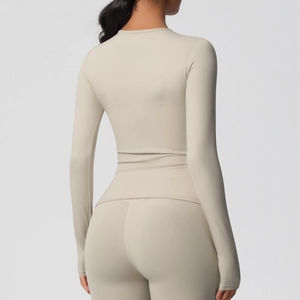 Vue arrière du haut de sport à manches longues beige clair et du legging de yoga