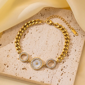 Detalle de pulsera de eslabones dorados con círculos de pavé e incrustación de nácar