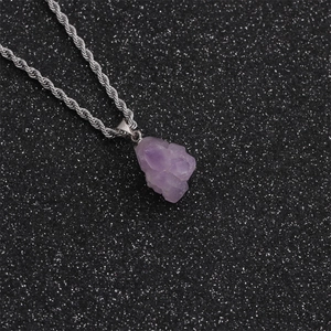Amethyst raw stone pendant necklace with silver twist chain on black textured background