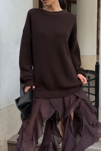 Detail of dark brown knit sweater with irregular layered lace skirt and handbag