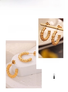 Macro detail of golden C-shaped hoop earrings with unique spiral bamboo texture finish