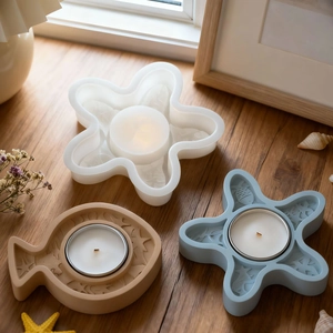 Detailed relief textures of starfish and fish resin candle holders on a wooden surface