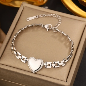 Detailed shot of silver heart pendant bracelet with geometric links on jewelry box