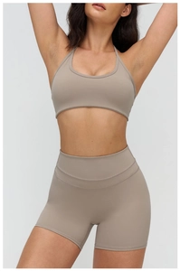 Vue de face d'un ensemble de yoga taupe avec brassière de sport et short de cycliste