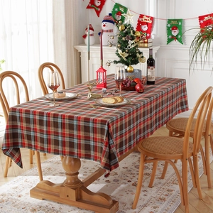 Classic red and blue plaid Christmas tablecloth on a wooden table in a festive dining room