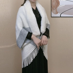 Close-up of knit shawl with gradient grey tones, plush faux fur collar and fringe tassels