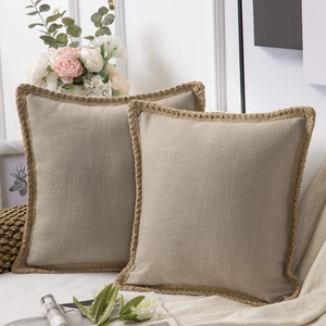 Detail of linen cushion covers with woven lace edges in a cozy home setting