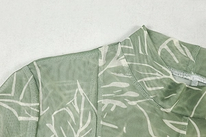 Detailed close-up of green mesh top featuring vintage floral print and stand collar stitching