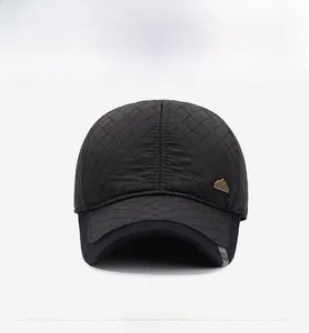 Detailed front view of black quilted baseball cap with diamond pattern and gold metal tag