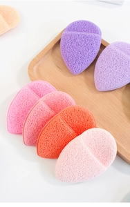 Macro detail of multi-colored teardrop facial sponges on a minimalist wood tray