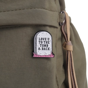 Gothic tombstone enamel pin with 'Love You To The Tomb & Back' text on canvas bag