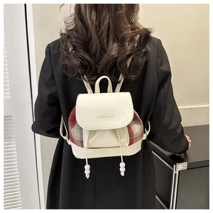 Detail eines Vintage-Mini-Rucksacks mit Karomuster, Kordelzug und Fashion-Schriftzug