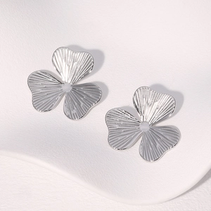 Silver flower stud earrings in stainless steel with textured radial petals on white