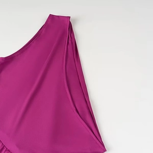 Gros plan sur la couture de l'épaule de la robe fuchsia et la texture du tissu en nylon
