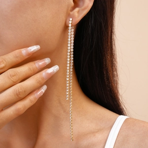 Detail view of elegant double long tassel earrings with sparkling cubic zirconia on model