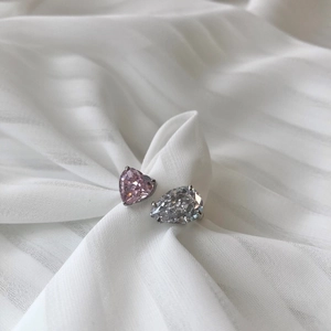 Detailed close-up of S925 silver ring featuring pink heart and pear cut stones on silk