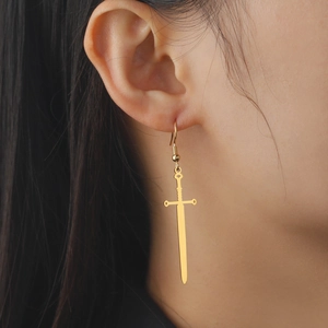 Gothic gold sword drop earrings for women worn by a model in a punk style jewelry shoot